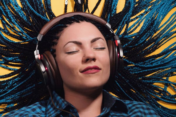 woman with eyes closed listening to music on studio headphones