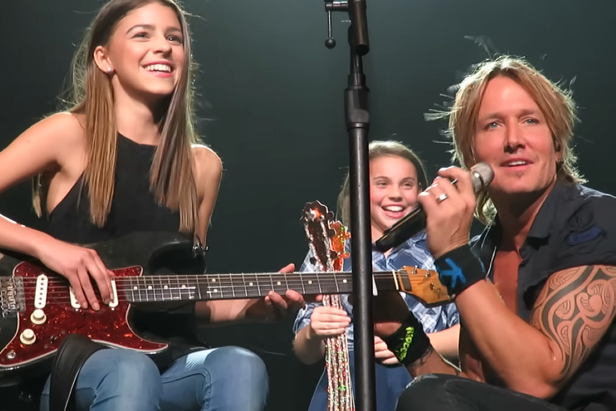 keith urban on stage with two young fans