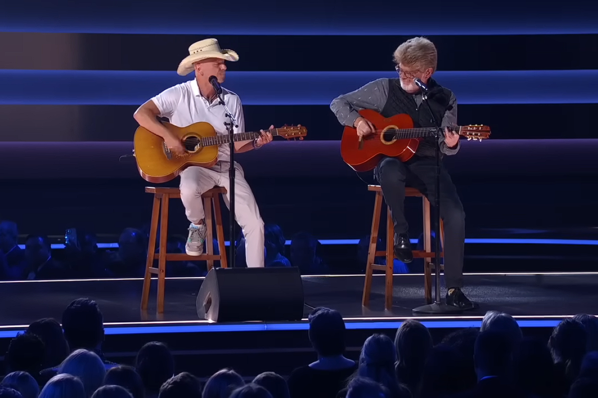 Kenny Chesney and Mac McAnally singing and playing guitar on stage