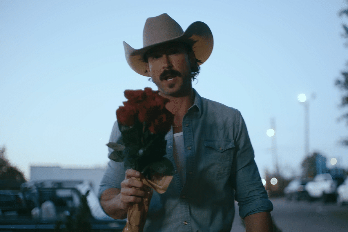 Riley Green holding a bouquet of flowers in his music video for "worst way"