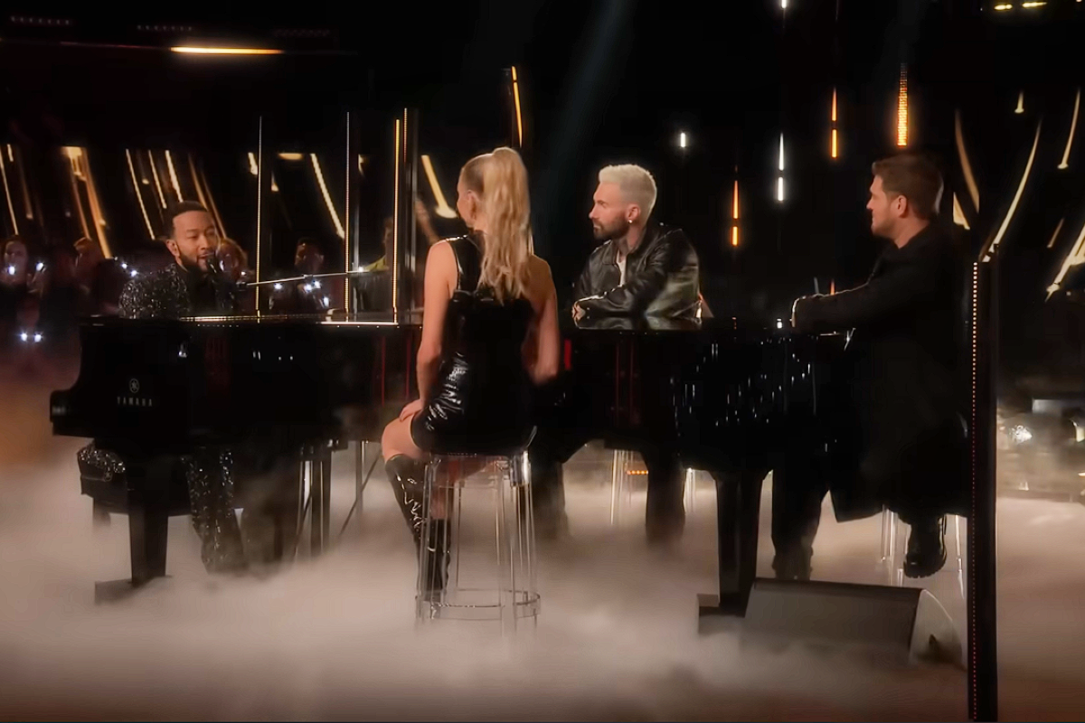 The Voice coaches sitting around a piano singing together