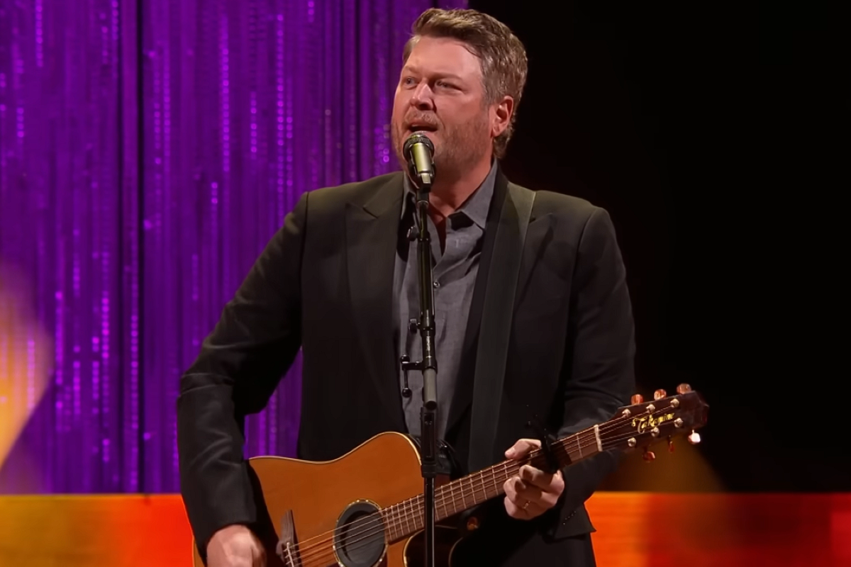 Blake Shelton singing and playing guitar on stage